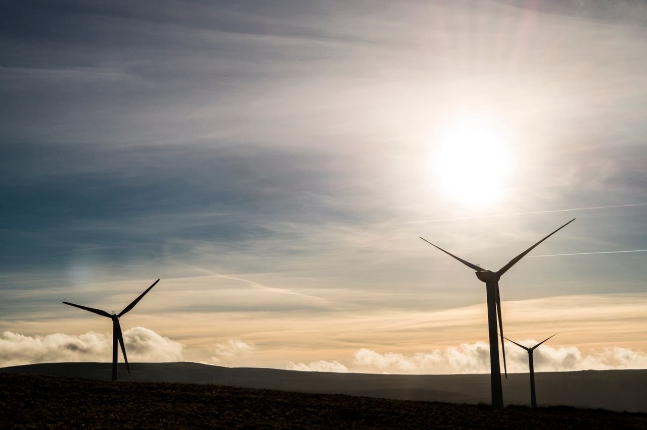 The Art of Drawing Readers In: Your attractive post title goes here Silhouetted wind turbines generate renewable energy against a stunning sunrise sky.
